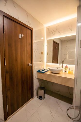 a bathroom with a sink and a mirror at Gold Central Hotel by Haviland in Da Nang