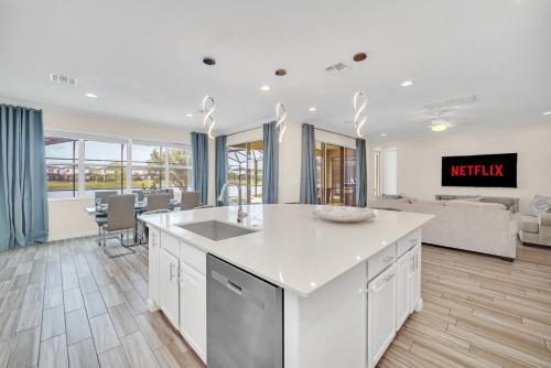 a kitchen with a sink and a living room at LAKE VILLA 6bd, all un-suite, pool, spa, grill in Kissimmee