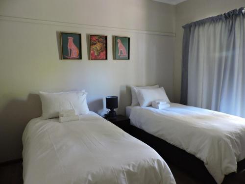 two beds sitting next to each other in a room at The Hamlet House in Prince Alfreds Hamlet