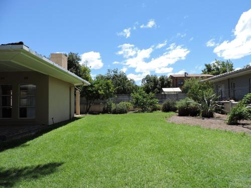 a yard of a house with green grass at The Hamlet House in Prince Alfreds Hamlet