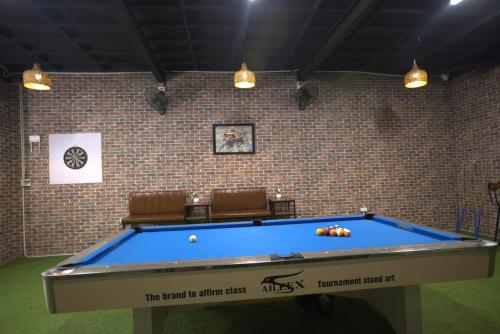 a pool table in a room with two chairs at Moc May by Northstar Hostel & Tours in Ha Giang