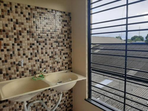 ein Badezimmer mit Waschbecken und Fenster in der Unterkunft Residencial Reis - Cozy and Comfortable Apto in Boa Vista