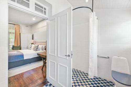 a bedroom with a bed and a desk and a door at The Houston Boutique Hotel Wagga in Wagga Wagga