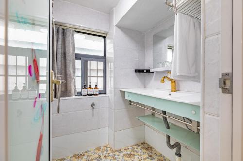ein Badezimmer mit Dusche, Waschbecken und Spiegel in der Unterkunft Guangzhou City Center Apartment in Guangzhou
