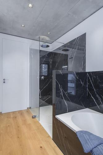 a bathroom with a black marble counter and a tub at Wohnen in der Villa Kunterbunt nahe der 5-Seen-Landschaft in Puchheim