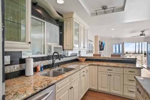 a kitchen with white cabinets and a sink at Beachfront Getaway with Ocean Views and Private Patio in Newport Beach