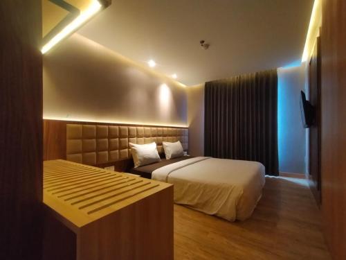 a hotel room with a bed and a couch at OPA Hotel Palembang in Sukarami
