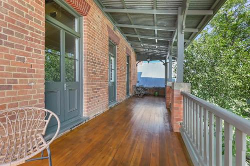 a porch of a brick building with a bench at The Houston Boutique Hotel Wagga in Wagga Wagga