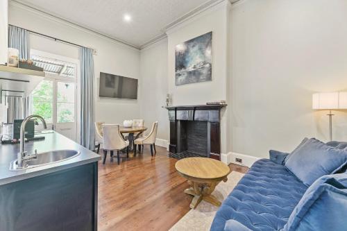 a living room with a blue couch and a kitchen at The Houston Boutique Hotel Wagga in Wagga Wagga