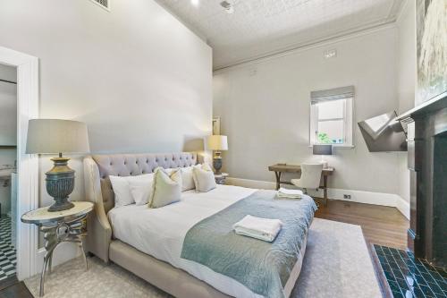 a bedroom with a large bed and a fireplace at The Houston Boutique Hotel Wagga in Wagga Wagga