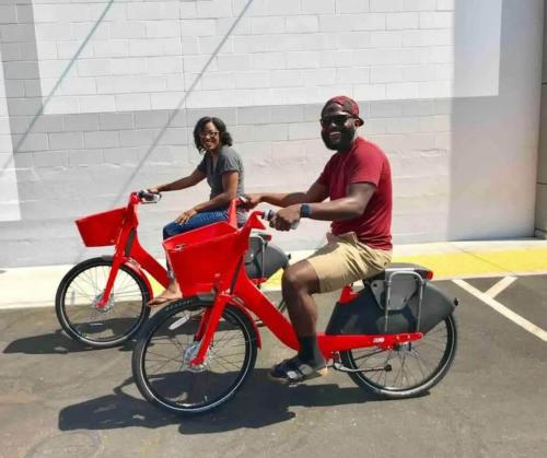 a man and a woman riding on a red bike at Central 2BR 1BA & Arcade Crib in the heart of Sac in Sacramento