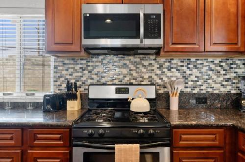 a kitchen with a stove and a microwave at 3BR 2BA Gem in Rancho Near Shop Centers & Eateries in Rancho Cordova