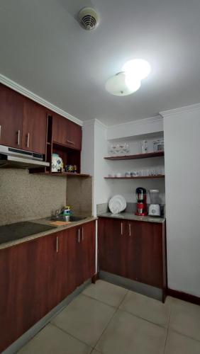 an empty kitchen with wooden cabinets and a sink at Riverfront2 II in Guayaquil