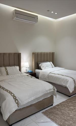 a bedroom with two beds and a air conditioner at Relax in Buraydah