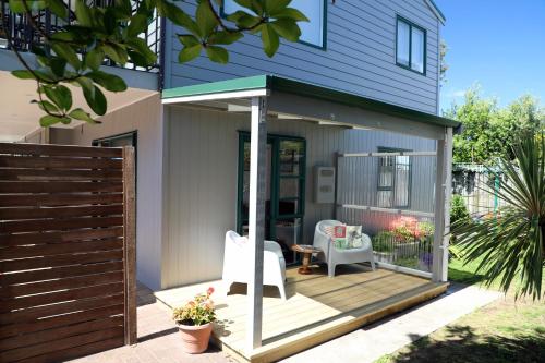 a screened in porch of a house with two chairs at Blue Marlin Apartments in Whitianga