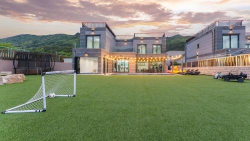 a house with a soccer ball on a grass field at Pause Kids Pool Viila in Yeosu