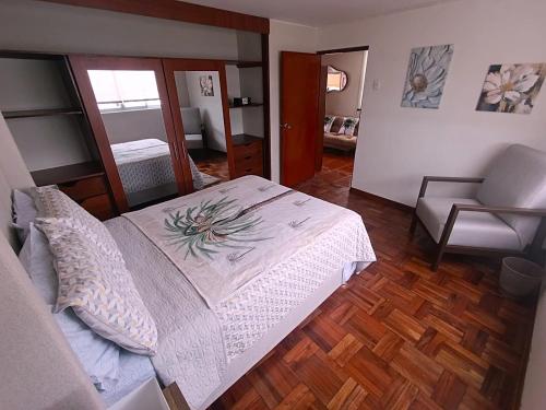 Un dormitorio con una cama grande y una silla en La Palmera, en Lima