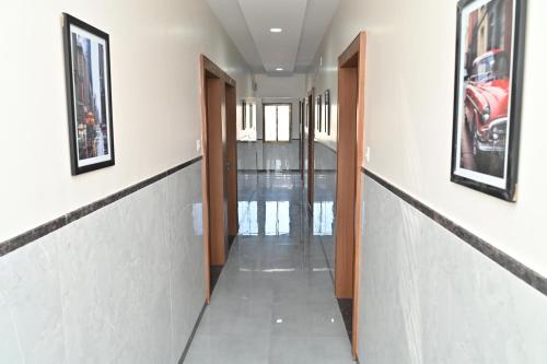 a hallway of a building with two doors and paintings at Hotel Sai Sneha in Shirdi