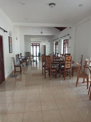 a dining room with wooden chairs and a table at Family Villa Serenity in Galle