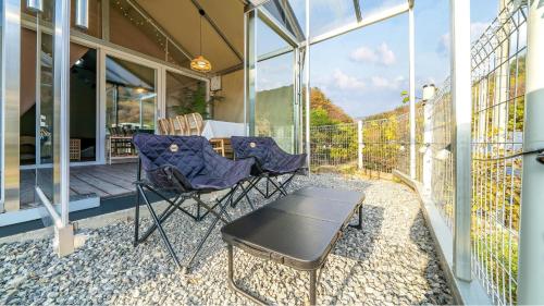 a patio with chairs and a table on a balcony at Gapyeong Ddobagi Pet & Spa Glamping in Gapyeong