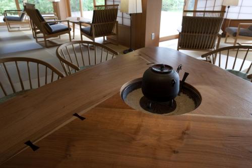 a black tea pot sitting on a wooden table at TAKITEI Riverside Onsen ーA Hidden Ryokan in Kanazawaー in Kanazawa