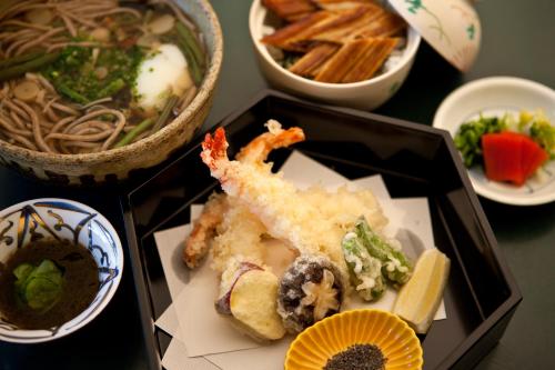 a plate of food on a table with bowls of food at TAKITEI Riverside Onsen ーA Hidden Ryokan in Kanazawaー in Kanazawa