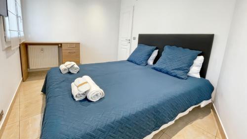 - une chambre avec un grand lit bleu et des serviettes dans l'établissement LHelvetia - 3 Bedrooms - 3 Bathrooms - near Croisette, à Cannes