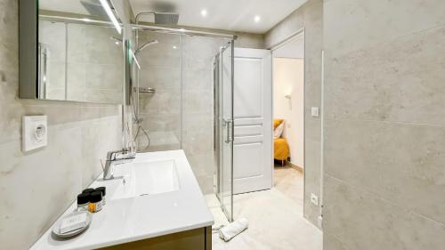 La salle de bains est pourvue d'une douche et d'un lavabo blanc. dans l'établissement LHelvetia - 3 Bedrooms - 3 Bathrooms - near Croisette, à Cannes