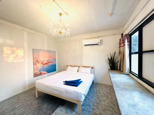 a bedroom with a white bed and a chandelier at Kohchang stayin premium hotel in beach street market in Ko Chang