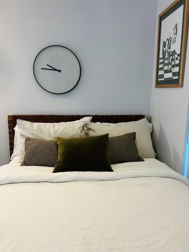 a clock on a white wall above a bed at Albert Park Haven in Melbourne