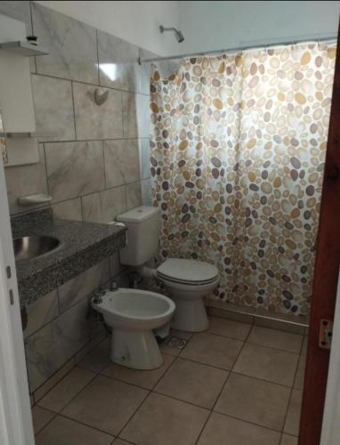 a bathroom with a toilet and a sink and a shower at Los cuatro soles in San José