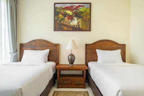 two beds sitting next to each other in a bedroom at Viki Nest by SooBali 4BR in Umalas