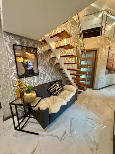 a living room with a couch and a spiral staircase at Country Haven Comfy & Sleek House in Monasterevin