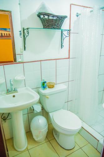 a white bathroom with a toilet and a sink at Hostal Fuente Castalia, B y B in León