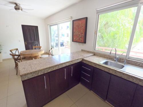 a kitchen with a sink and a large window at Margaritas Condos in Downtown of Playa in Playa del Carmen