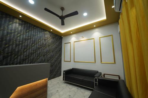 a waiting room with a couch and a ceiling fan at Brij Hari Villa in Varanasi