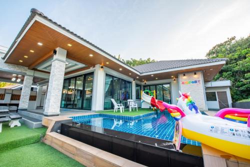 a house with a swimming pool with a inflatable pool slide at Airport Pool Villa บางเสร่ in Bang Sare