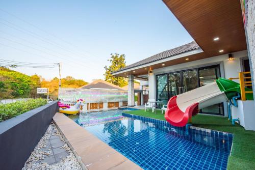 a pool with a slide in a house at Airport Pool Villa บางเสร่ in Bang Sare