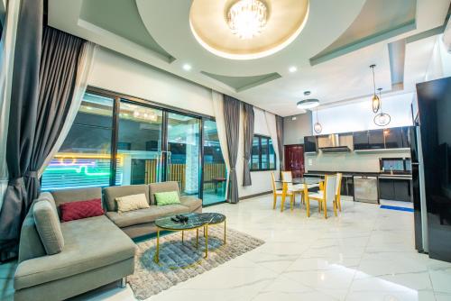 a living room with a couch and a table at Airport Pool Villa บางเสร่ in Bang Sare