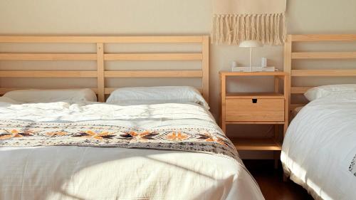 a bedroom with two twin beds and a night stand at Sol Stay Osaka 桜シーズン特惠 in Osaka