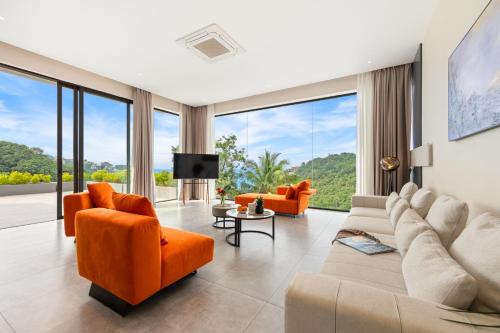 a living room with orange furniture and large windows at Green Lotus Samui in Ban Bang Po