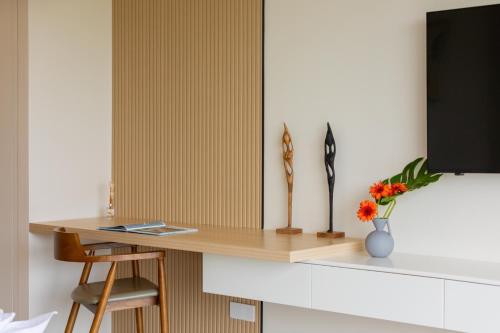 a desk in a room with a vase of flowers at Green Lotus Samui in Ban Bang Po
