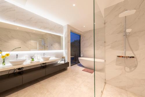 a bathroom with two sinks and a glass shower at Green Lotus Samui in Ban Bang Po