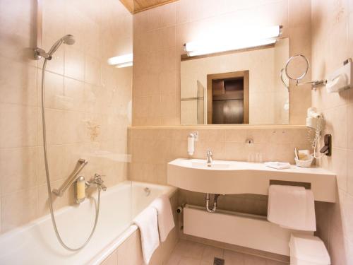 a bathroom with a sink and a shower and a tub at Hotel Müller in Hohenschwangau