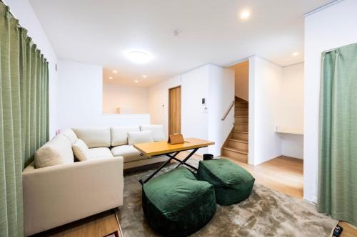 a living room with a couch and a table at Port House Fukuoka in Fukuoka