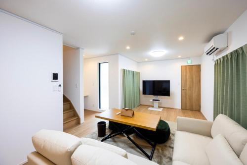 a living room with a couch and a table at Port House Fukuoka in Fukuoka