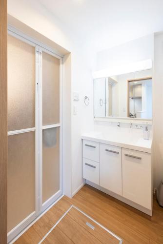 a bathroom with a sink and a mirror at Port House Fukuoka in Fukuoka