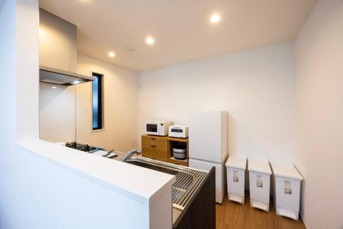 a kitchen with white appliances and a white refrigerator at Port House Fukuoka in Fukuoka
