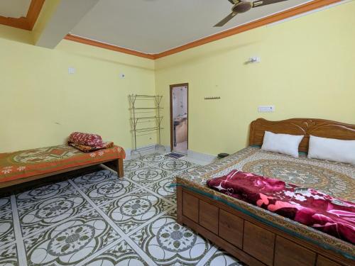 Un dormitorio con dos camas en una habitación. en Narasimha Dev Guest House, en mayapur