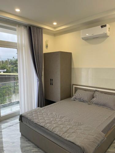 a bedroom with a large bed and a window at Hiệp Phát in Buôn Kô Tam